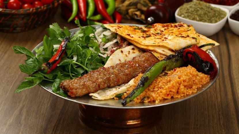 adana kebab with bulgur on table